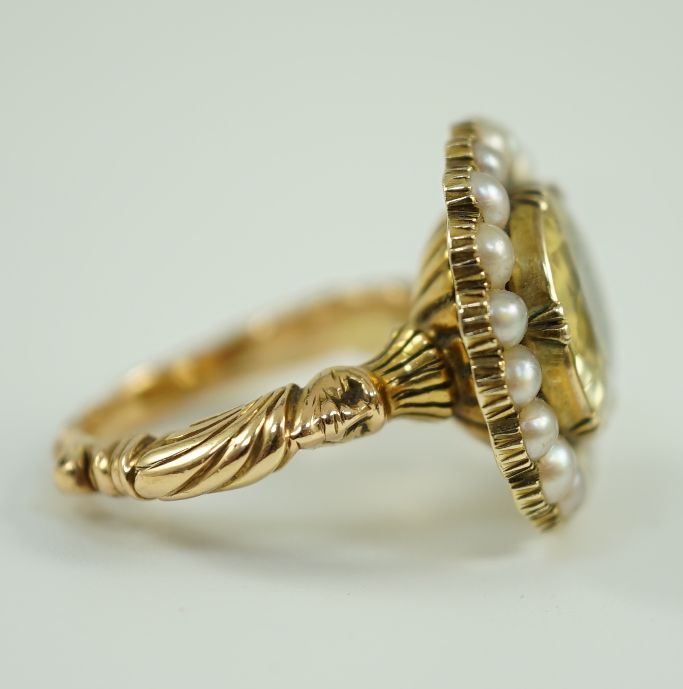 A 19th century style gold and round cut single stone yellow sapphire set dress ring, with split pearl set border